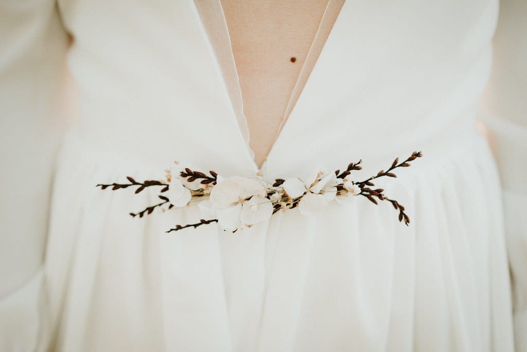 Robe de mariée décolletée plongeant avec bande en orgonza et broche amovible en fleurs séchées et stabilisées - Fleuriste " Atelier Aimer " Nantes
