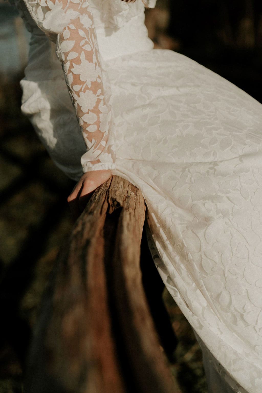 Détails tissu robe de mariée transparent fleurs blanches floquées